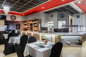 a restaurant with tables and chairs and a counter at The Royal Courtyard in Matatiele