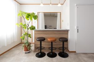 a kitchen with two stools and a counter with a mirror at ラベンダー富士 富士山と過ごすおしゃれな隠れ家 in Fuji