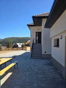 a patio with benches and stairs in front of a building at Apartmány ALMA Šumiac in Šumiac