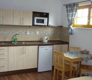 a kitchen with a white refrigerator and a table at Apartmány Na Kobylce in Modrava
