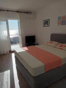 a bedroom with a large bed and a balcony at Villa BORIĆ DARKO in Podgora