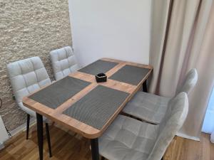a dining room table with chairs and a box on it at Apartman Adria Lux Doboj in Doboj +4 photos