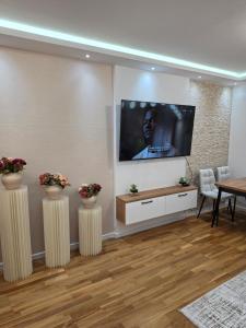 a living room with a flat screen tv on a wall at Apartman Adria Lux Doboj in Doboj