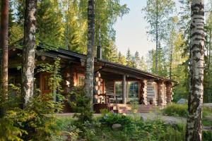 a log cabin in the woods with trees at Hawkhill Resort in Tervalampi