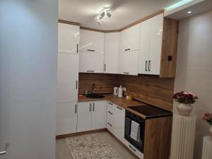 a kitchen with white cabinets and a sink at Apartman Adria Lux Doboj in Doboj