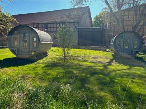 two cottages in the grass in a yard at Obstgarten im Warnetal- Campingfass Kobel in Gielde