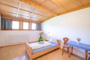 a large room with a bed and a table at Rieplhof - Relaxing farm stay with breakfast and mountain view in Vipiteno