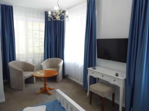 a living room with a television and a table and chairs at Millennium Villa in Keszthely