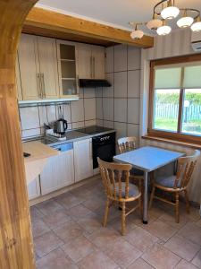 a kitchen with a table and chairs and a table at Guest House Naglis in Neringa