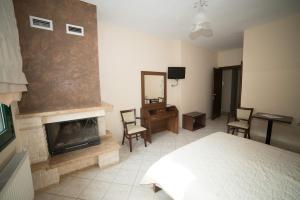 a bedroom with a fireplace and a bed and a mirror at Hotel Galaxias in Kato Loutraki