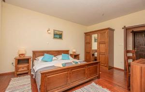 a bedroom with a large wooden bed with blue pillows at Villa Ruzin Dvor in Donji Vinjani +54 photos