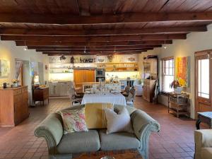 a living room with a couch and a kitchen at Classic Home in Franschhoek in Franschhoek