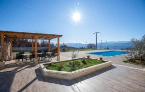 a patio with a table and chairs and a pool at Villa Ruzin Dvor in Donji Vinjani