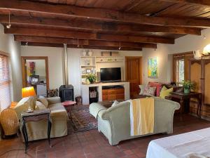a living room with couches and a flat screen tv at Classic Home in Franschhoek in Franschhoek
