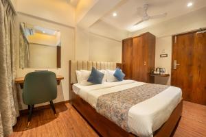 a hotel room with a bed and a desk at Hotel Kalpana Palace, Mumbai in Mumbai