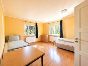 a room with two beds and a table and two windows at Gemütlich Wohnen in Kahla bei Jena in Kahla