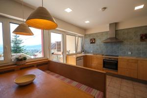 eine Küche mit einem Holztisch und einigen Fenstern in der Unterkunft Casa Blanco in Cercedilla
