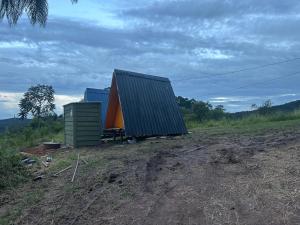 a small house sitting on top of a dirt field at Bangalô Cachoeira Bem Vinda in Itabirito