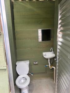 a bathroom with a toilet and a sink at Bangalô Cachoeira Bem Vinda in Itabirito