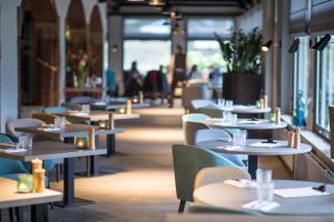 una fila de mesas y sillas en un restaurante en Bilderberg Hotel De Bovenste Molen, en Venlo
