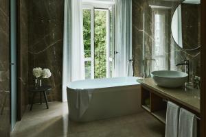 a bathroom with a tub and a sink and a window at Belvedere Bellagio in Bellagio