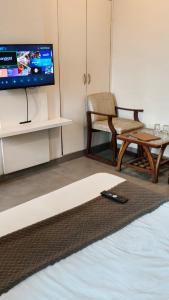 a room with a tv and a chair and a table at Hotel Chandigarh Elite in Chandīgarh +33 photos