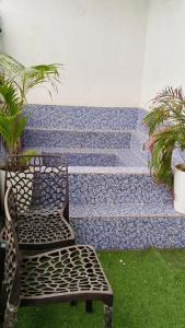 a chair sitting next to a bench with plants at Hotel Chandigarh Elite in Chandīgarh