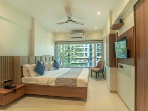 a bedroom with a bed and a large window at Hotel Kalpana Palace, Mumbai in Mumbai