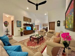 a living room with a couch and a table and a tv at Suite Room The Megatruh in Kejayan