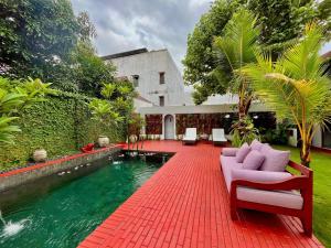 a house with a swimming pool and a red brick patio at Suite Room The Megatruh in Kejayan