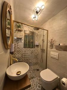 a bathroom with a sink and a toilet and a shower at Serenity Stone en las Sierras in Benaoján