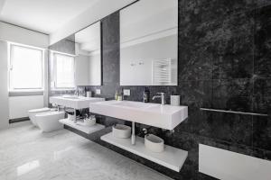 a bathroom with two sinks and a large mirror at Urbanicooh Cavour Rooms&Suite in Bologna +77 photos