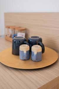 a group of four coffee cups sitting on a plate at Urbanicooh Cavour Rooms&Suite in Bologna