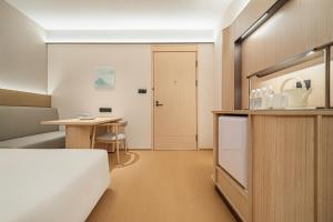 a small room with a table and a door at Ji Hotel Phnom Penh Downtown in Phnom Penh