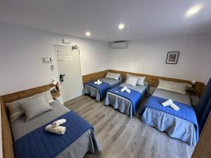 three beds in a room with blue beds at Malva Hostel Estartit in L'Estartit