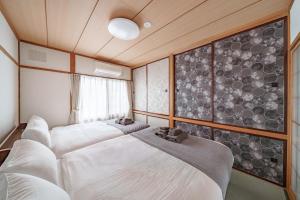 a room with three beds and a wall of windows at Sapporo Nakajima Parkhouse in Sapporo