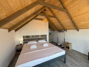 a bedroom with a large bed with wooden ceilings at Complex Turistic Răsărit Corbu in Corbu