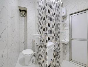 a white bathroom with a toilet and a sink at HOTEL Sarovar in Ahmedabad