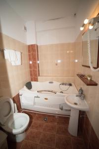 łazienka z wanną, toaletą i umywalką w obiekcie Hotel Galaxias w mieście Kato Loutraki