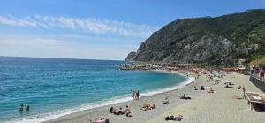 a group of people on a beach near the ocean at Monterosso - Apartment in Monterosso al Mare