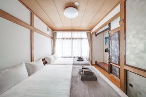 two beds in a room with a large window at Sapporo Nakajima Parkhouse in Sapporo