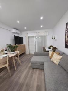 a living room with a couch and a table at Casa Bella Arch, 2 min walk to beach Praia da Rocha in Portimão