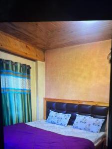 a bedroom with a large bed with purple sheets at Jakhu heights B&B in Shimla