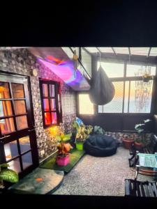 a living room with a couch and a room with windows at Jakhu heights B&B in Shimla