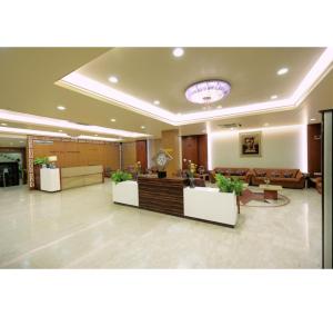 a lobby with a waiting area with couches and tables at Hotel Prince, Bhuj in Bhuj