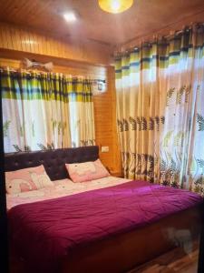 a bedroom with a large bed with curtains at Jakhu heights B&B in Shimla