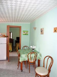 a dining room with a table and chairs and a refrigerator at Mare e relax in Tropea