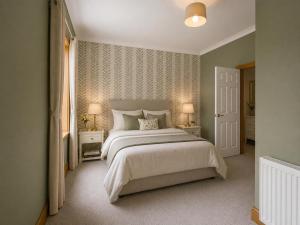 a bedroom with a large bed and two lamps at North Lodge - NC500 in Helmsdale