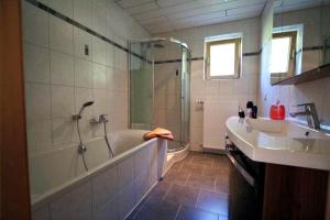 a bathroom with a shower and a tub and a sink at Salzleckerhof in Lambach +17 photos
