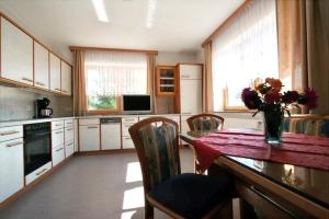 a kitchen with a table with a vase of flowers on it at Salzleckerhof in Lambach